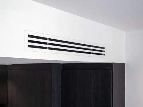 Air conditioning vent on wall ceiling in hotel room interior, featuring ven.. Stock Photos