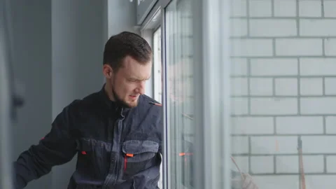 Air conditioning wizard. A man at high altitude installs air conditioning Stock Footage 195936033