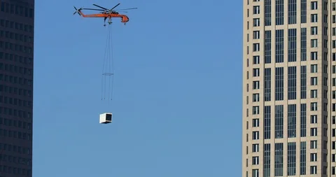 Air Crane removing material from down town skyscraper. Stock Footage 89447310