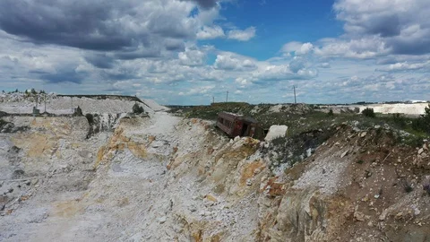 Air flight on a summer day, an old carriage stands on the edge of a quarry Stock Footage 128284451