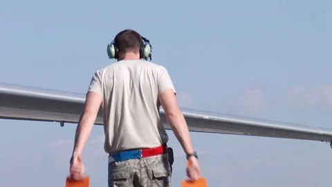 Air Force Controller Directing C-17 Cargo Plane on Tarmac Stock Footage 72652933