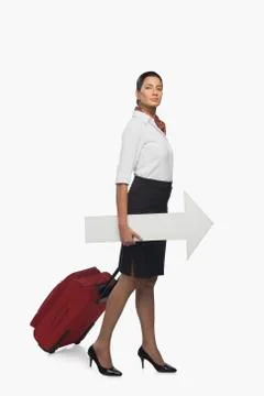 Air hostess carrying luggage with an arrow sign Stock Photos