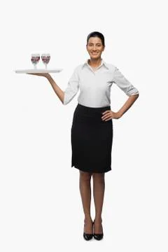 Air hostess carrying a tray of wine glasses Stock Photos
