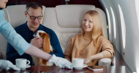Air hostess serving coffee for mature couple in first class cabin Stock Photos