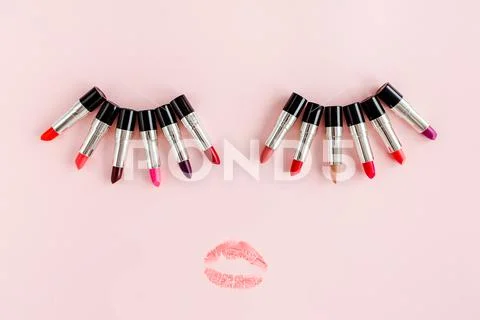 Air kiss and set of color lipsticks on pink background. Professional decorative Stock Photos