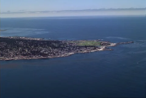 From the air over Monterey Bay, the camera approaches the coastline of Pacific Stock Footage 86773116