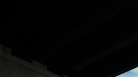 Air plane flying viewed emerging from overpass 動画素材 121072097