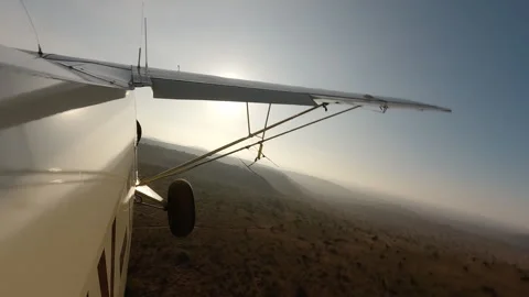 Air plane side view flying low over dry savannah at morning Stock Footage 310969110