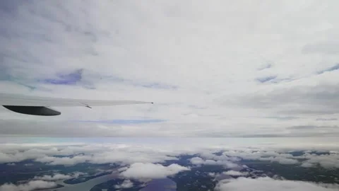 Air plane window view time lapse clouds and blue sunny sky Stockbeeldmateriaal 277017797