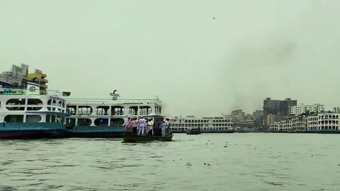 Air polluted by black smoke by Small engine boat with Muslim passenger at ship Stock Footage 334812185