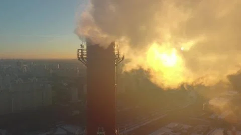 Air polluting industrial smoke stack close-up shot on sunset background in urban 写真素材