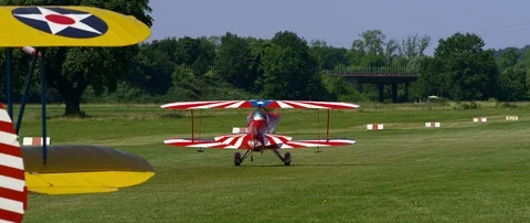 Air show, bright red Pitts S1-E biplane aerobatic rolls to the runway Stock Footage 101315081