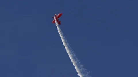 Air show, bright red Pitts S1-E biplane aerobatic plane in the blue sky. Vidéo 101330160