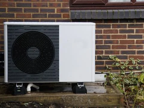 Air Source heat pump fitted outside a house Stock Photos