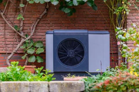 Air source heat pump unit installed on the exterior. Stock Photos
