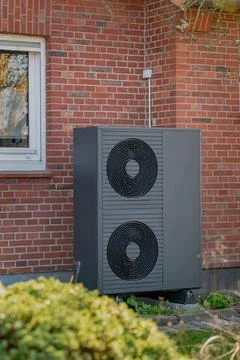 Air-source heat pump unit with two circular fans. Stock Photos