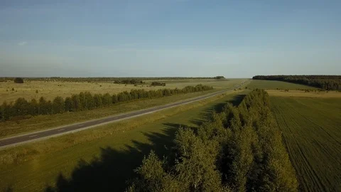 Air survey the road in field at sunset Stock Footage 102464483