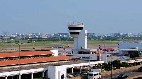 Air traffic control tower overseeing airport operations cityscape aerial view Stock Footage 335976643