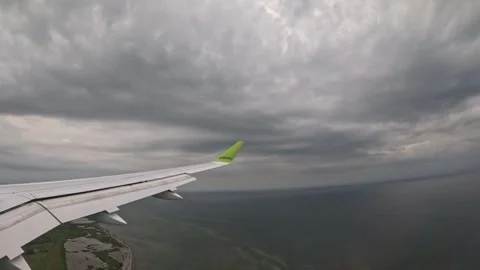 AirBaltic airplane banking low over green coastline and shallow bay waters Stock-Footage 340320577