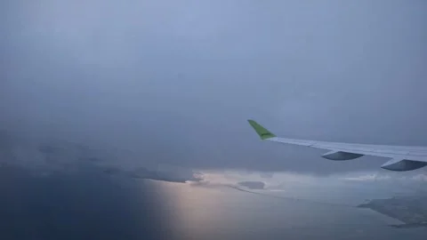AirBaltic airplane entering clouds over Oresund Bridge and Strait at sunset Stock Footage 340228890