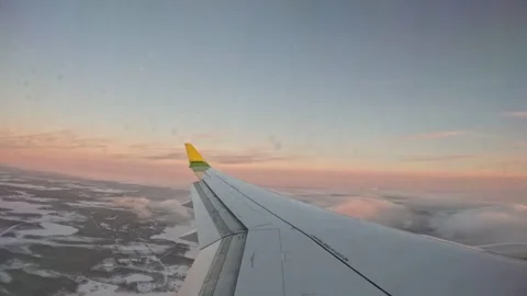 AirBaltic airplane wing gliding over low cloud and snow landscape at sunset Vídeo Stock 342533848