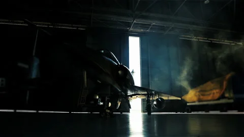 Airbase Hangar Doors Opening with Light and Fighter Plane Silhouette - 4K Stock Footage 152749042