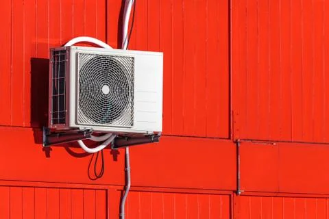 Airconditioning unit on a red wall Stock Photos