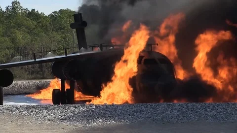 Aircraft burning in flames and fire trucks approaching Stock Footage 101669276