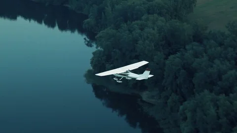 Aircraft cessna flies over the forest and the river Stock Footage 80308950