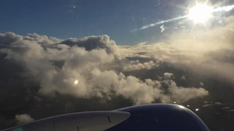 Aircraft climbing through clouds toward blue sky and sun Vídeos de archivo 83960821