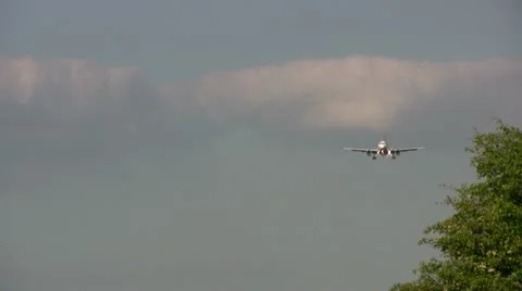 Aircraft coming in by trees Stock Footage 22100100