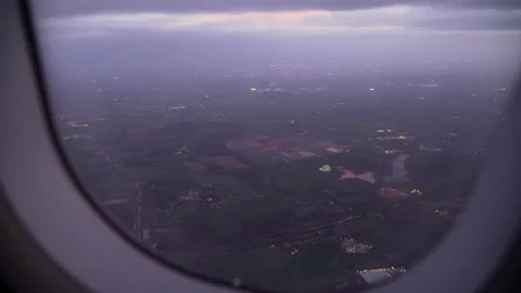 Aircraft cruising over patchwork farmland and small towns under cloudy evening Stockbeeldmateriaal 334041029