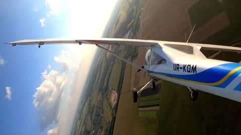 Aircraft in flight, showcasing dynamic aerial maneuvers over lush green fields Stock Footage 324803882
