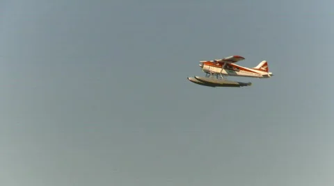 Aircraft, float plane flies past cargo ship incoming Stock Footage