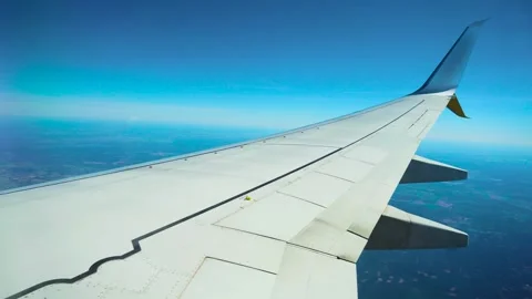 Aircraft flying above patchy forest and farmland. Passenger jet cruising over Stockbeeldmateriaal 331160248