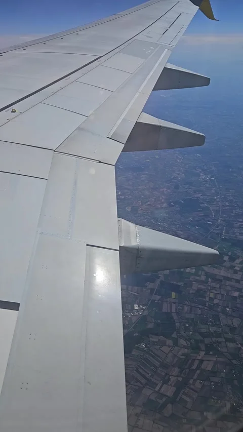 Aircraft flying again over patchwork farmland. Plane cruising high above fields Video stock 312598730