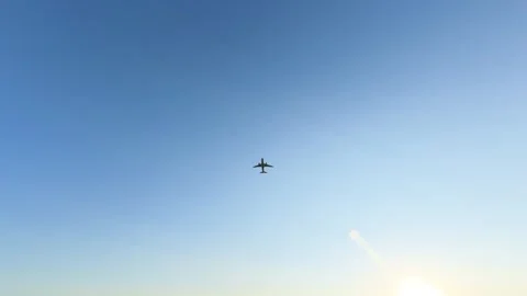 Aircraft flying in clear sky at sunset during evening hours Stock Footage 342263259