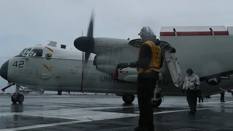 Aircraft handler directing C-2A Greyhound taxiing aboard USS Abraham Lincoln Stock Footage 106442563