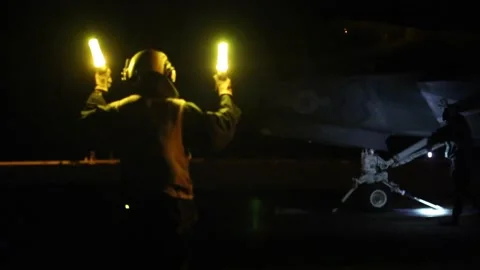 Aircraft handler directs F-35B with illuminated wands aboard USS Abraham Lincoln Vidéo 218595302