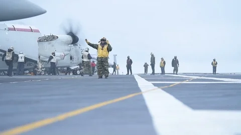 Aircraft handler guiding F/A-18 Hornet taxiing aboard USS Theodore Roosevelt Video stock 108535343