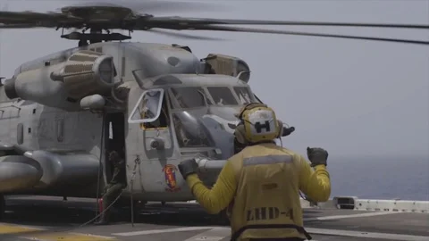 Aircraft handler signalling to pilot of CH-53 Super Stallion aboard USS Boxer Видео 114001416