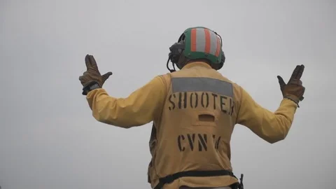 Aircraft handler signals aboard aircraft carrier Видео 101373837