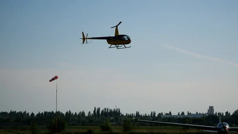 Aircraft helicopter flying in the sky over the airfield and biker Stock Footage 126123747