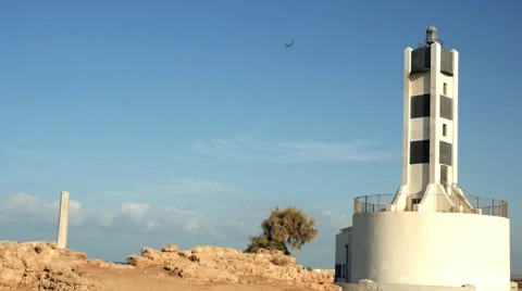 Aircraft landing behind lighthouse 库存影片 68853384