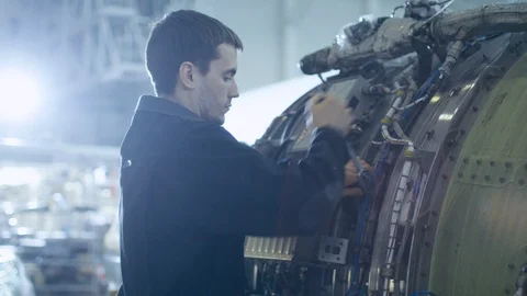 Aircraft Maintenance Mechanic Inspecting and Working on Airplane Jet Engine Stock Footage 106513472