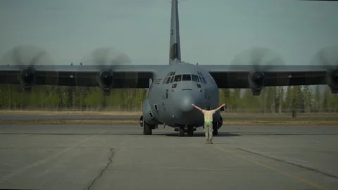 Aircraft marshaller signalling to pilot of C-130 Super Hercules Stock Footage 108378460