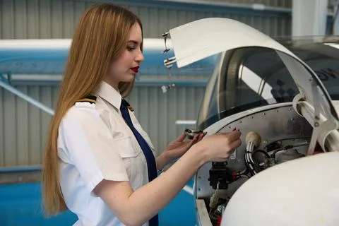 Aircraft mechanic performing maintenance on engine in hangar Stock Photos