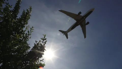 Aircraft passing through the sun on final approach Stock Footage 146661930