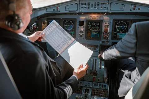 Aircraft pilot studying documents before the flight in cockpit Stock Photos