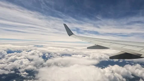 Aircraft plane Wing of flying in clouds and blue sky airplane as seen by Stock Footage 241600883
